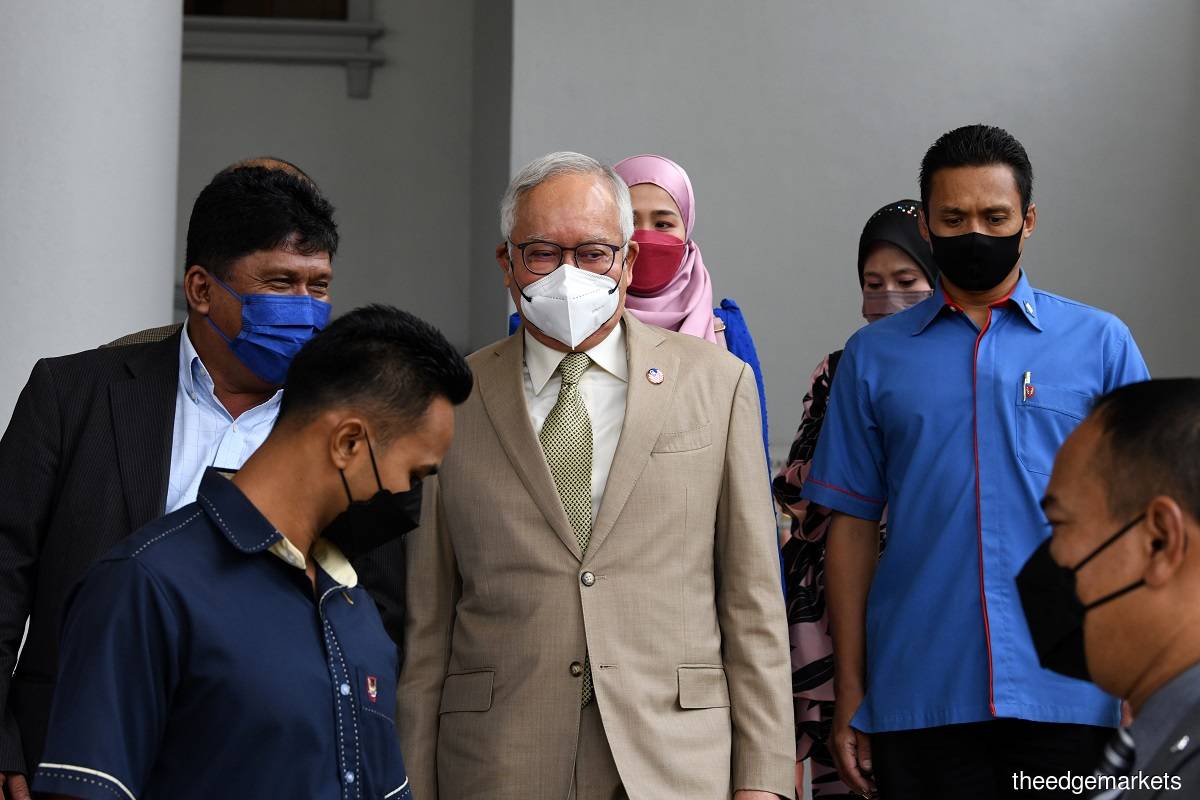 The former premier (centre) is charged with four counts of abuse of power involving RM2.28 billion and 21 counts of money laundering including nine for illegal proceeds, five counts of using the illegal proceeds and seven for transferring the proceeds to other entities. (Photo by Low Yen Yeing/The Edge)